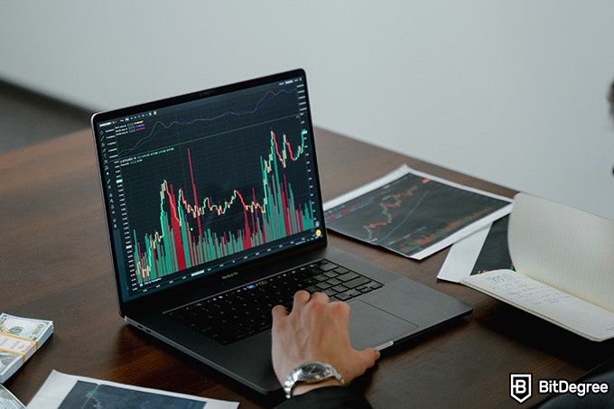 Best crypto exchange Canada: a man in front of a laptop with some graphs.