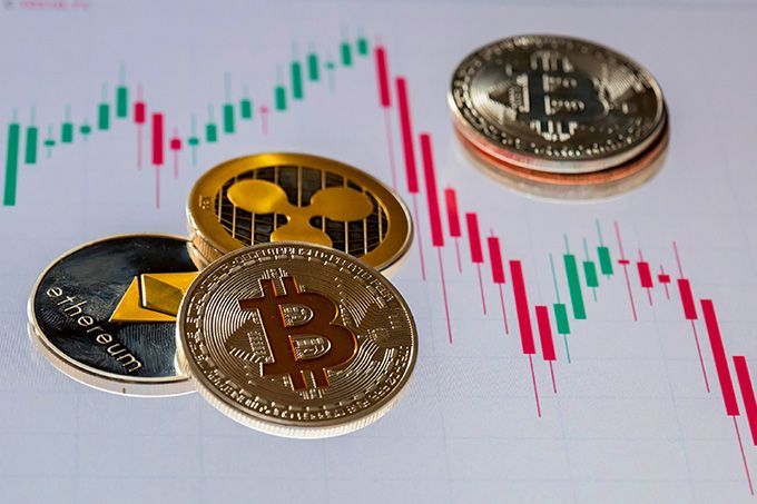 Cryptocurrency Exchange Terbaik: koin kripto berserakan di kertas grafik.