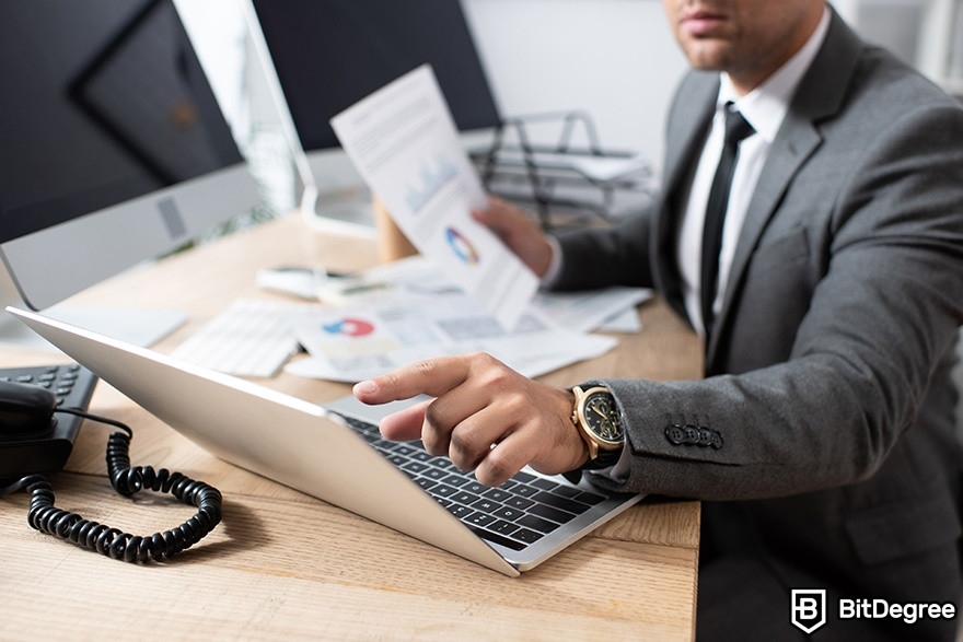 Best cryptocurrency broker: a man pointing at a laptop.