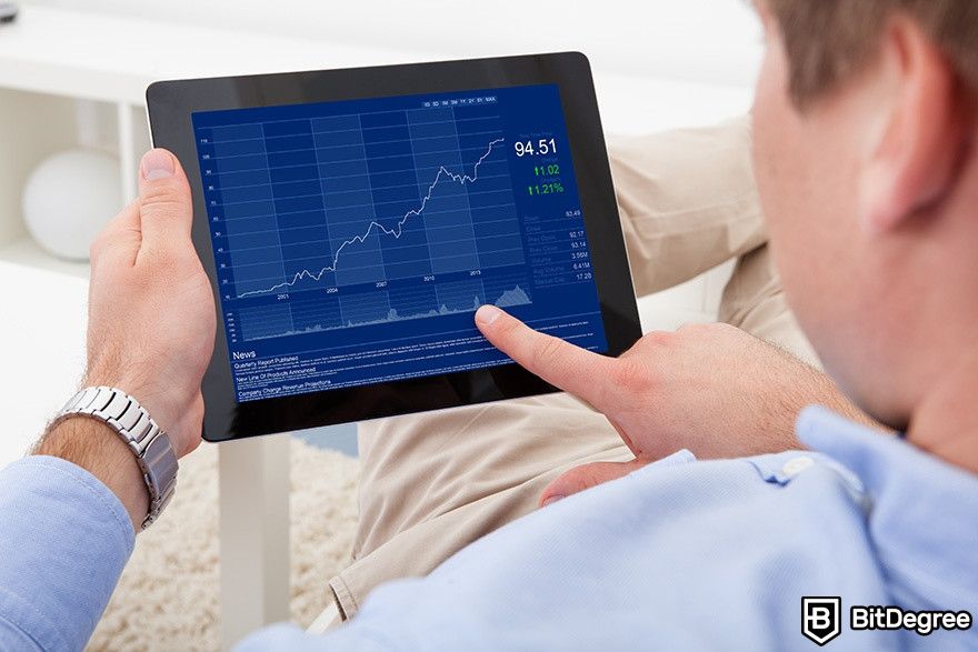 Best cryptocurrency broker: a man pointing at a tablet with some charts.