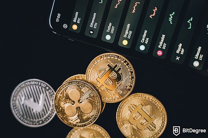 Best time to buy Bitcoins: different physical crypto coins near a phone.