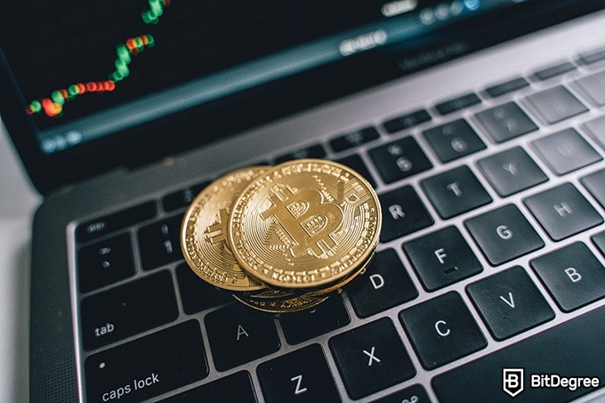 Best time to buy Bitcoins: physical Bitcoins stacked on a laptop keyboard.