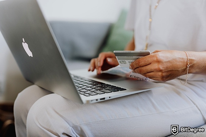 Crypto wallet deals: a woman entering banking details into a laptop.