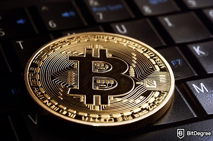 Penipuan DeFi: Koin fisik Bitcoin di atas keyboard.