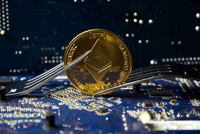 Forks da Ethereum: uma moeda entre dois garfos (forks).