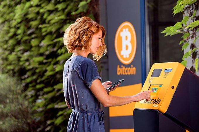 Cách mua tiền ảo: một cô gái tại máy ATM Bitcoin.