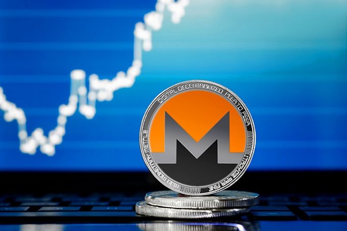 Como Comprar Monero: moeda Monero numa mesa.