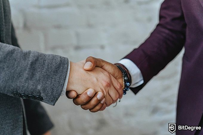 How to convert Bitcoins on Binance: two people shaking hands.