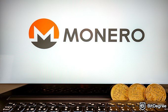 Đào Monero: Các đồng xu tiền Monero được xếp ông xã lên nhau trước màn hình hiển thị PC.