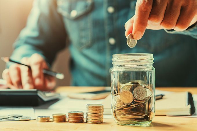 What is a cryptocurrency: a man placing coins into a jar.