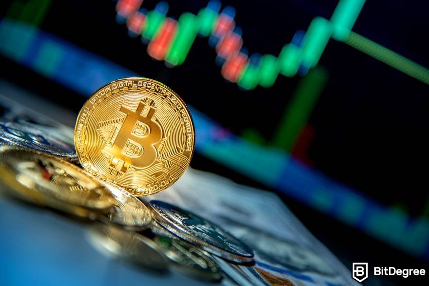 Giao dịch tiền điện tử AI: Bitcoin vật lý được đặt trước màn hình kỹ thuật số hiển thị biểu đồ thị trường.