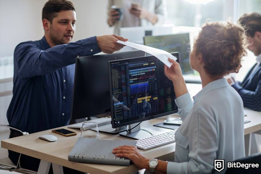 AI crypto trading: a man is handing a woman a sheet of paper.