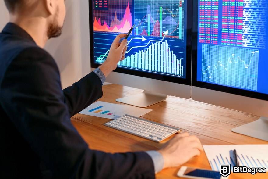 AI crypto trading: a trader is analyzing the market using two monitors.