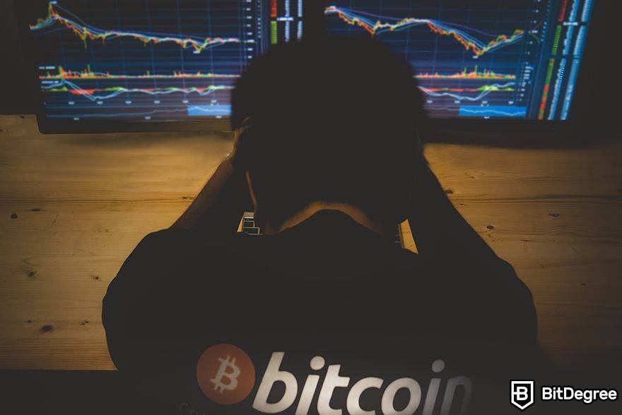 .btc domain: man watching two trading screens.