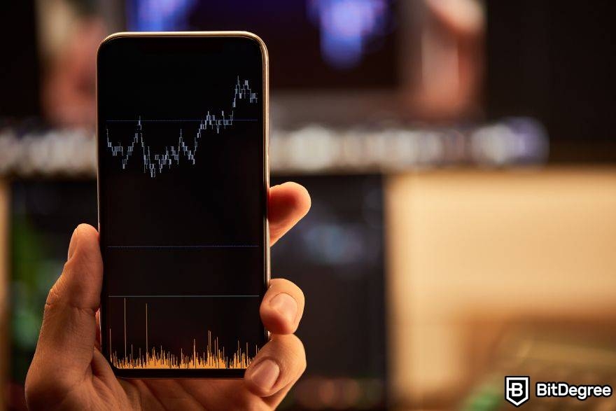 Crypto trading strategies: a person holding a phone, showcasing a chart movement.