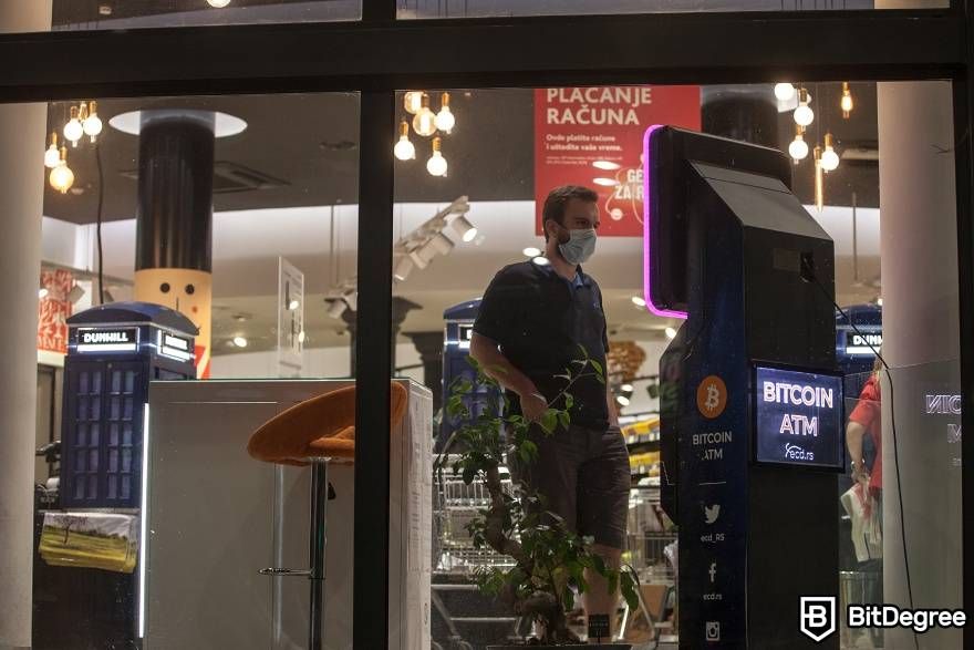 How does a Bitcoin ATM work: man standing near at BTM.
