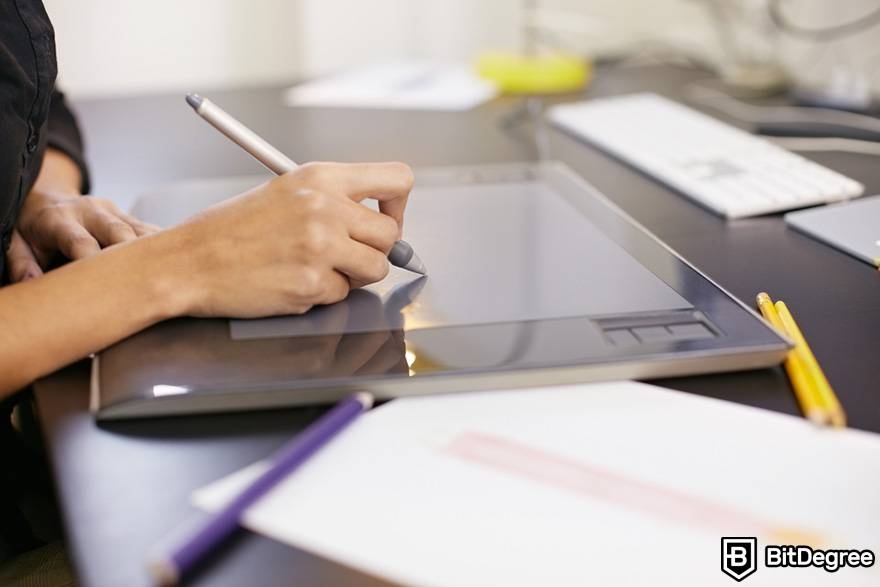 How to create NFT art: A woman drawing in a tablet.