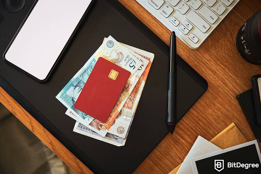 Tiền pháp định trong tiền điện tử là gì: một thẻ nướng được đặt trên một đống tiền giấy bảng Anh.