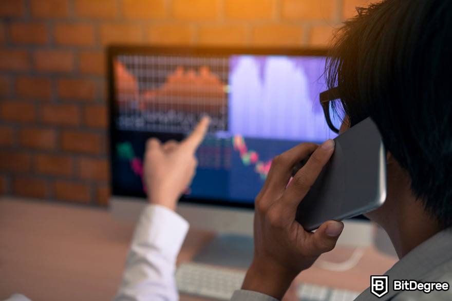 What is leverage trading crypto: an investor is making a phone call while looking at market charts.