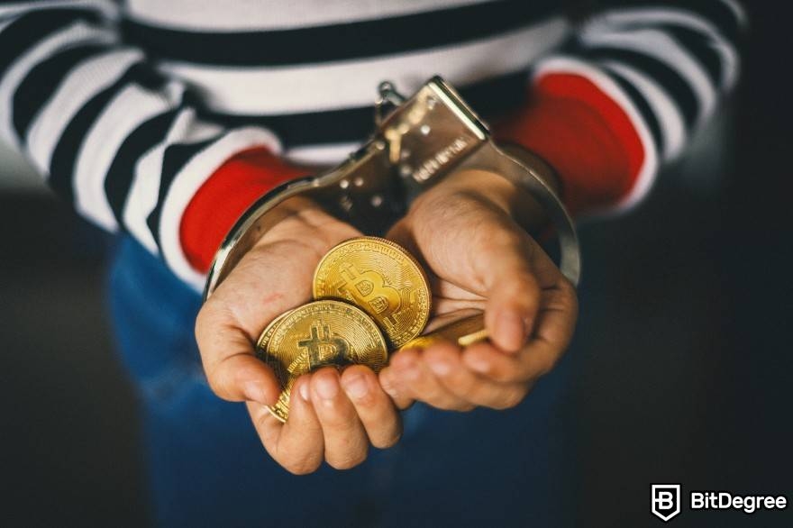 What is wash trading crypto: a handcuffed man holding a pile of physical BTC coins.