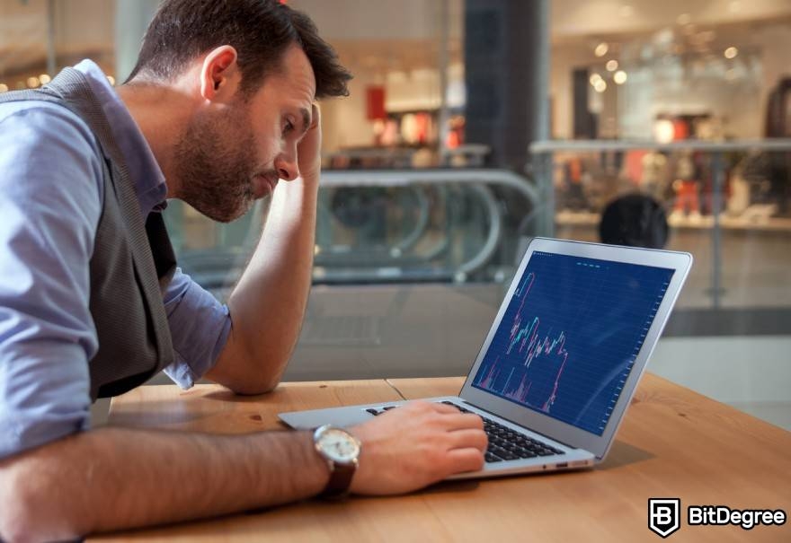 What is wash trading crypto: a frustrated man looking at financial charts.