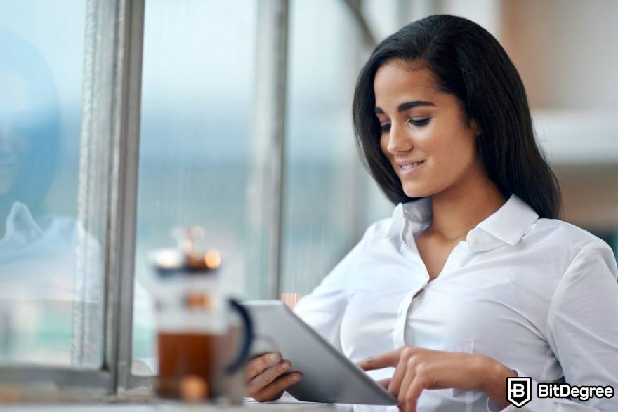 What is wash trading crypto: a woman looking at her tablet.