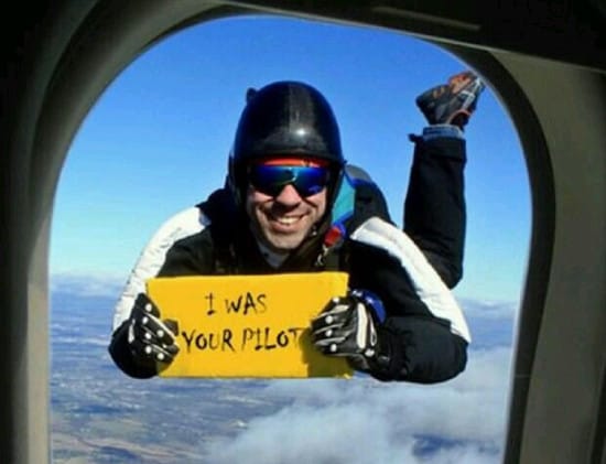 Image of a guy outside the plane window holding a sign that says "I was your pilot"