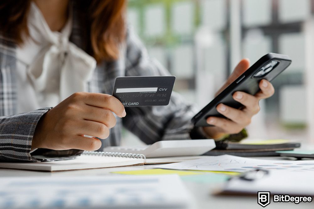 Application of blockchain: a woman holding a credit card for paying services online.