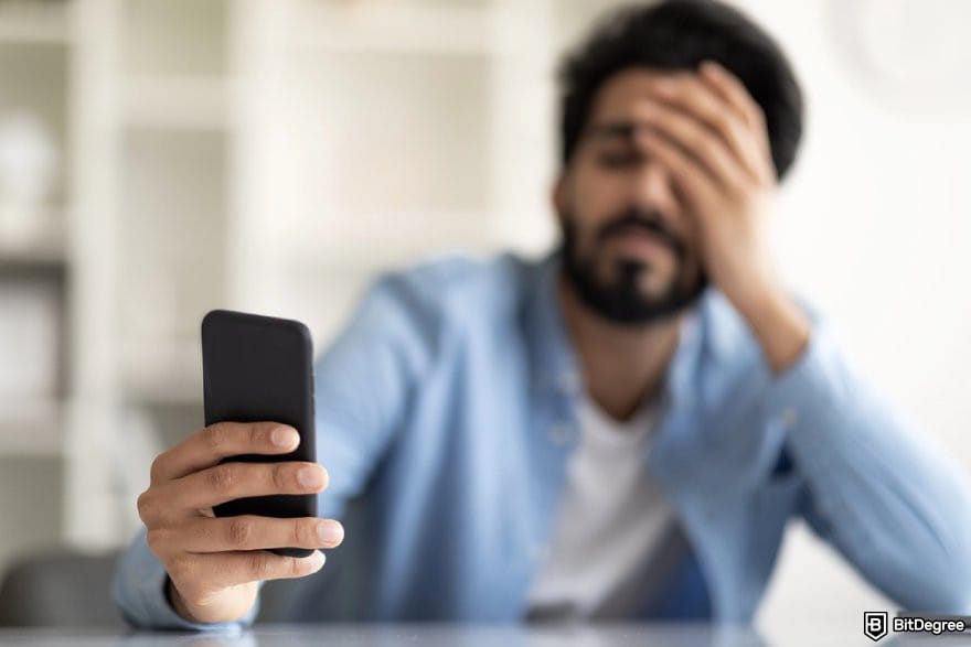 Atomic review: a person looking at a phone while covering their face.