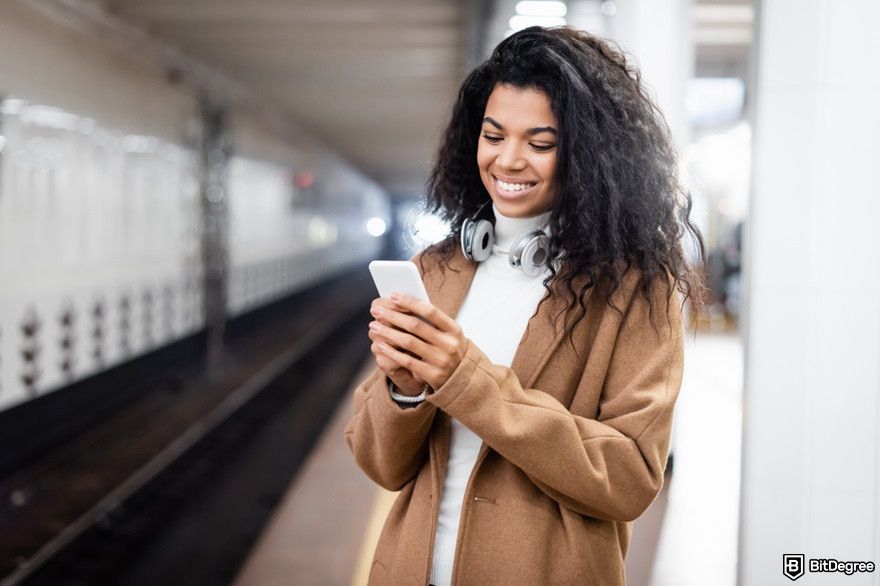 Best Arbitrum wallet: a woman using her phone happily.