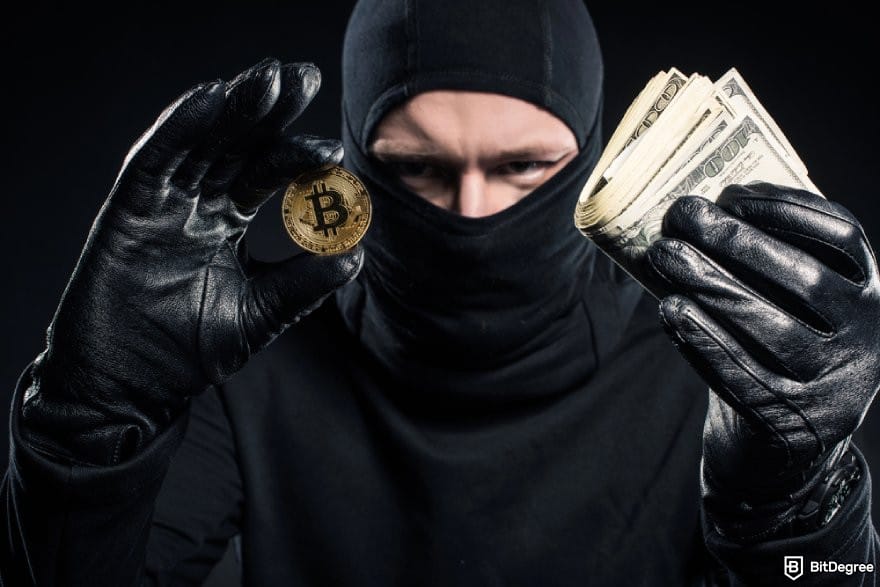 Ví Bitcoin tốt nhất: Một người đeo khẩu trang cầm đồng BTC và những tờ tiền 100 USD.