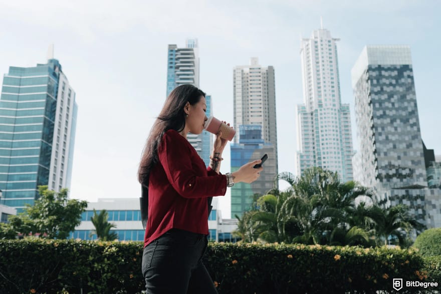 Best Chainlink wallet: a woman walking with a mobile in hand.