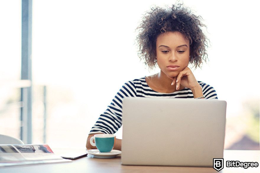 Best crypto affiliate programs: a person using a laptop on a wooden desk.