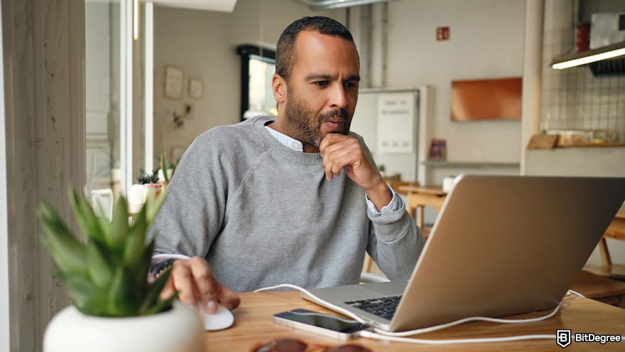Best crypto airdrops: a man looking for an airdrop at his laptop.