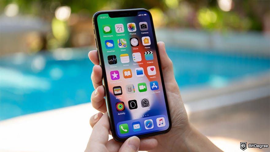 Best crypto app for beginners: person holding iPhone by the pool.