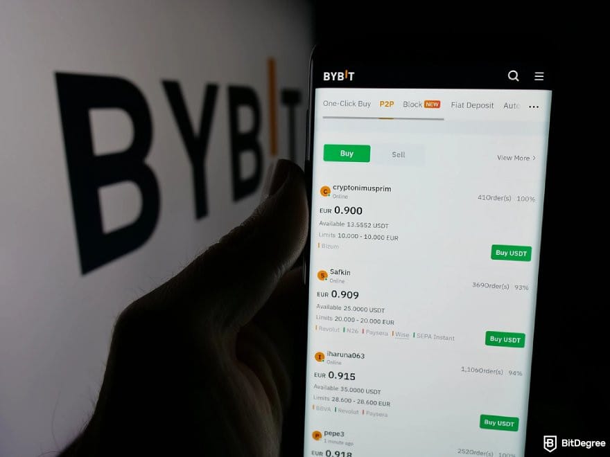 Best crypto exchange Australia: a hand holding a phone displaying Bybit P2P page.
