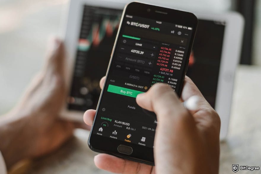Best crypto exchange for day trading: a person holding a phone showing Binance's trading interface.