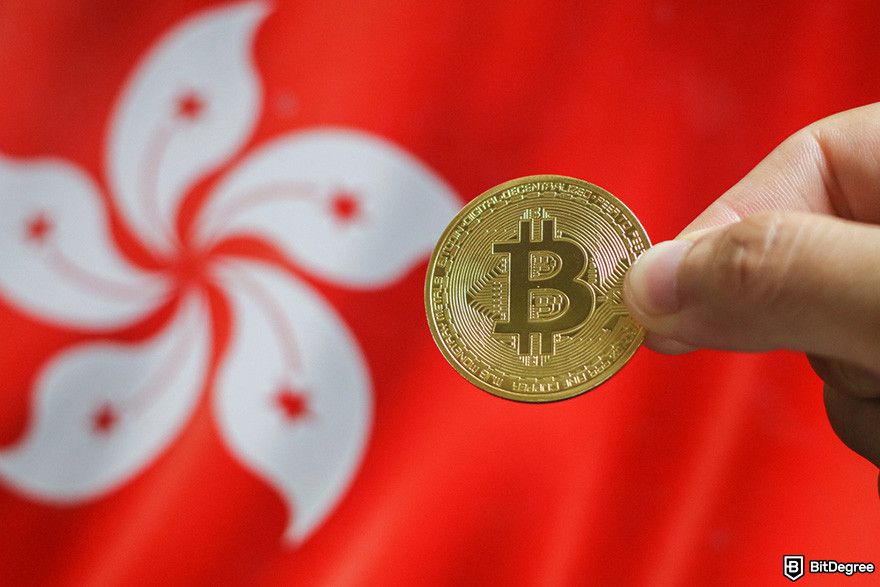 Best crypto exchange Hong Kong: a hand holding a BTC coin in front of the Hong Kong flag.