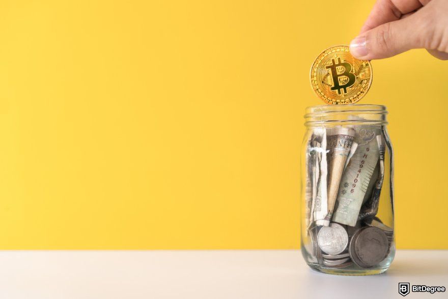 Best crypto under a penny: a hand putting a BTC coin into a glass jar filled with money.