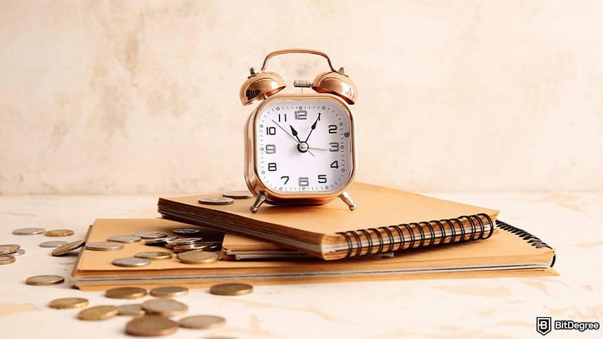 Best cryptocurrency of the year: alarm clock on notebooks and coins.