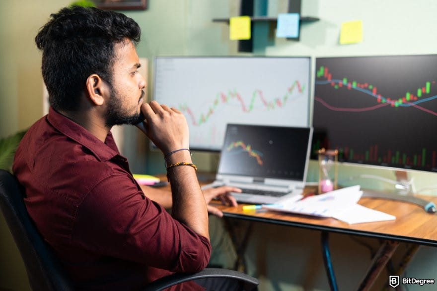 Best cryptocurrency to invest today for short term: a person looking at multiple monitor displaying price charts.
