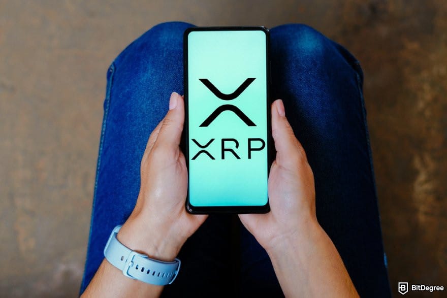 Best cryptocurrency to invest today for short term: a person holding a phone displaying the XRP logo.