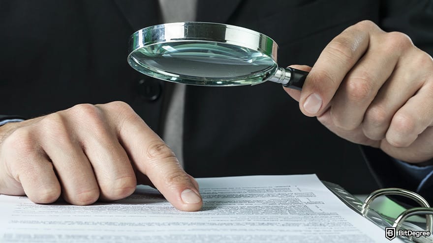 Best stablecoin: a close-up of a person's hand as it writes while also holding a magnifying glass.