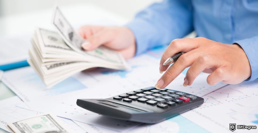 Best way to send money from US to Canada: a person holding dollar bills while using a calculator.