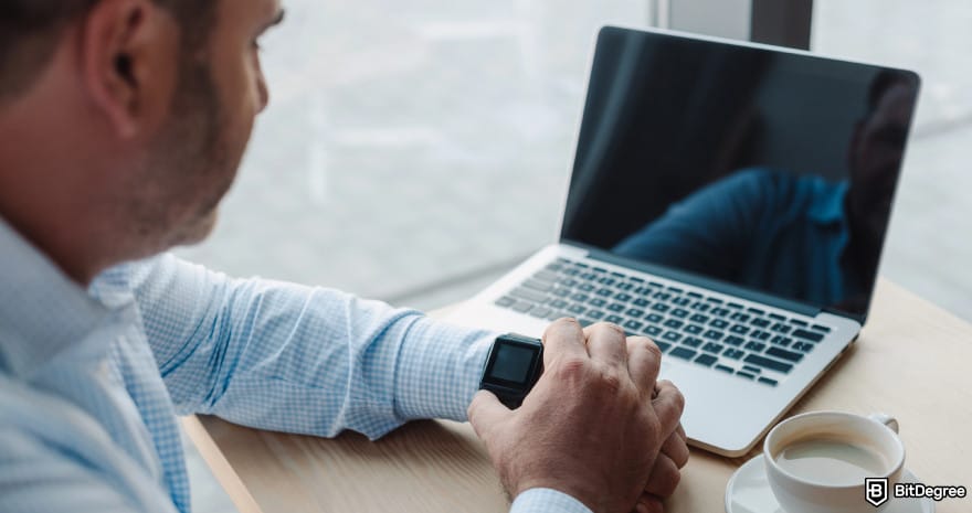 Best way to send money to Canada: a businessman checking the time on his smartwatch.