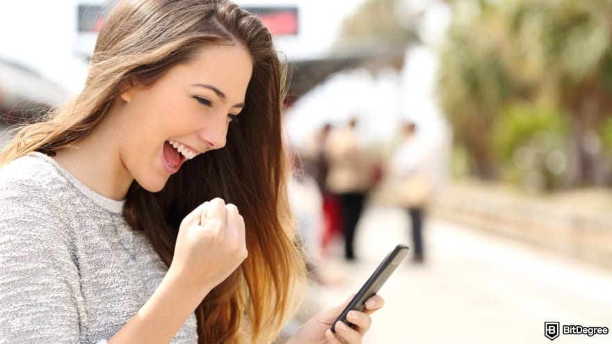 Best way to send money to Mexico: euphoric woman watching her smart phone.