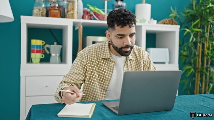 Best way to send money to Mexico: a young man using laptop writing notes.