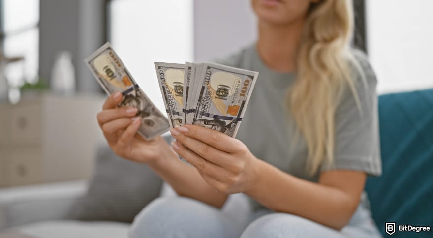 Best way to send money to Nigeria: woman holding US dollars to illustrate counting money to send.