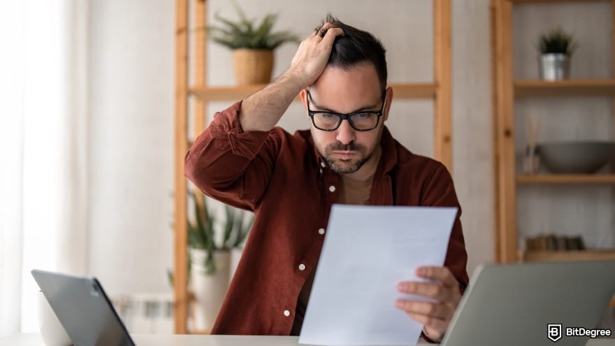 Best way to send money to Portugal: a person looking at paper document holding hand on his head.