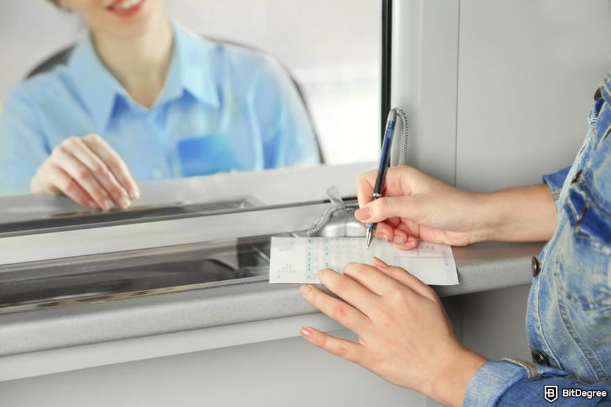 Best way to send money to UK: a woman making a transaction by the teller window.